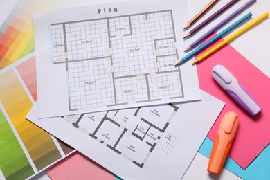 Photo of Designer's workplace with house plans, color palettes and stationery on table, top view