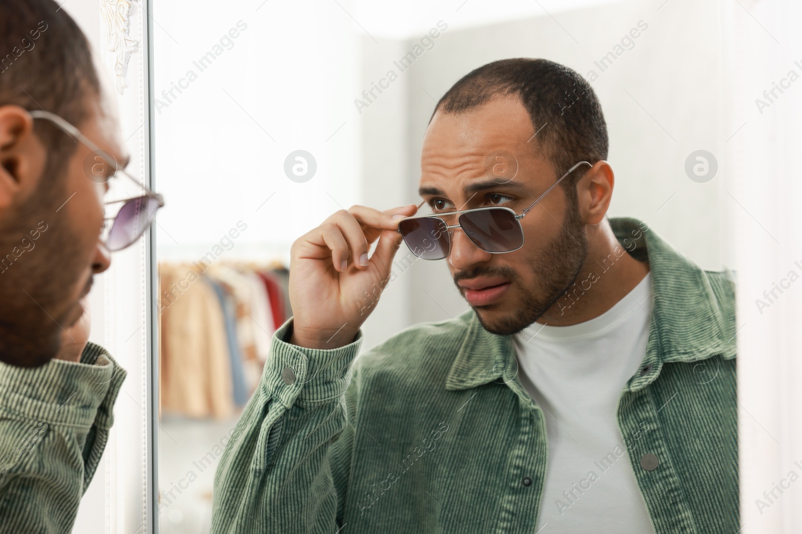 Photo of Handsome man looking at mirror at home