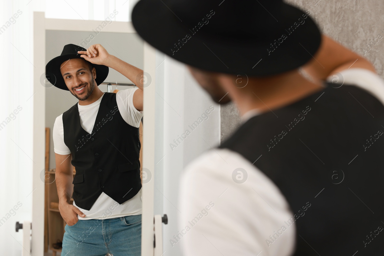 Photo of Smiling man looking at mirror at home