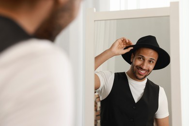 Photo of Smiling man looking at mirror at home