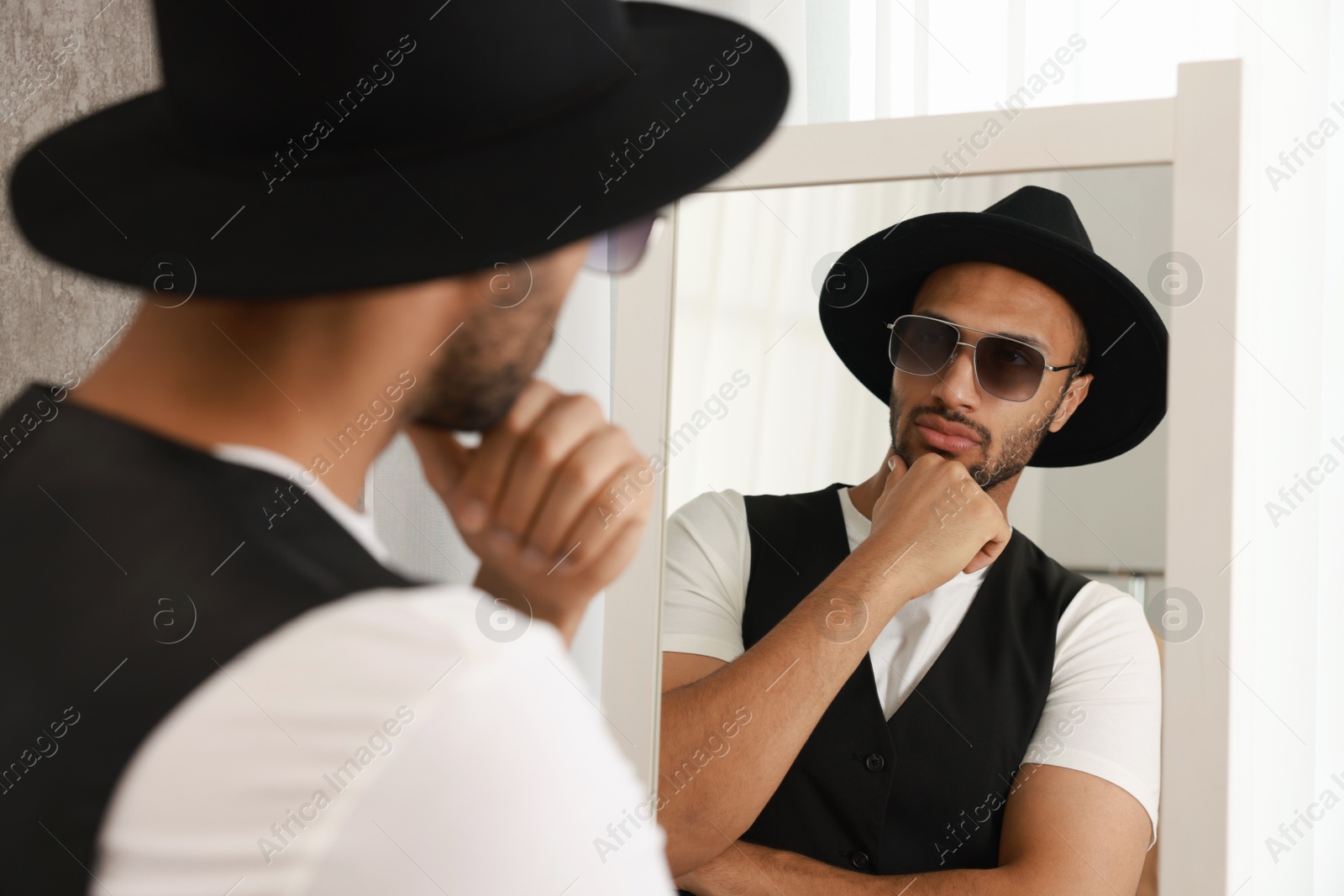 Photo of Handsome man looking at mirror at home