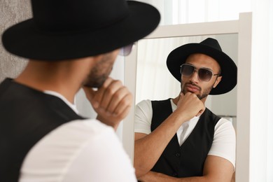 Photo of Handsome man looking at mirror at home