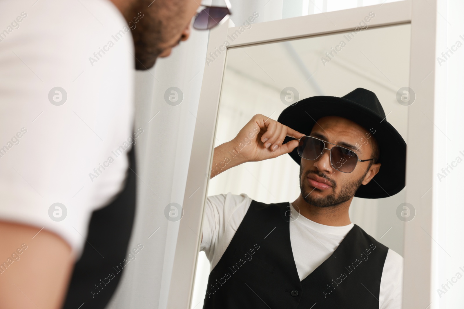 Photo of Handsome man looking at mirror at home