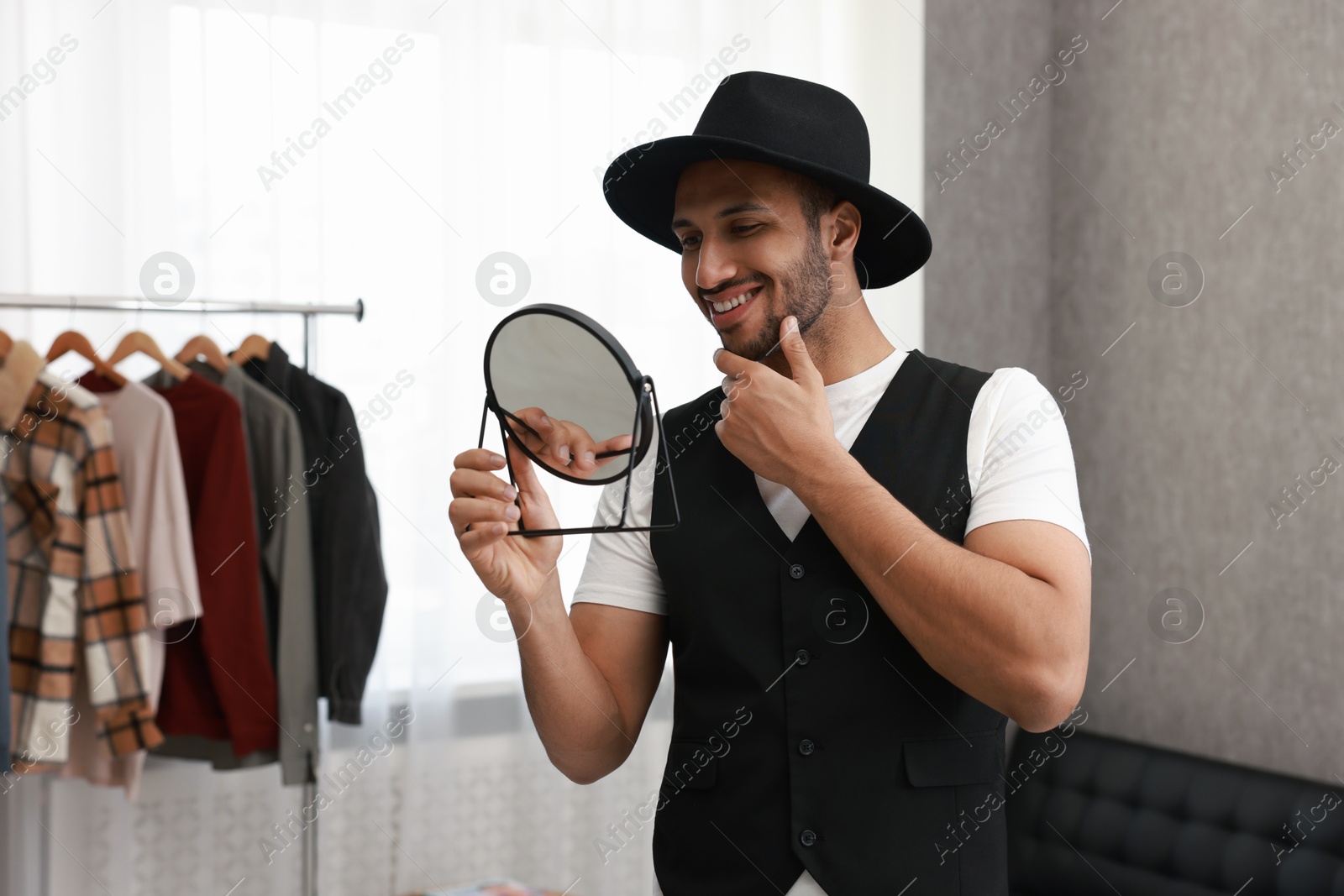 Photo of Smiling man looking at mirror at home