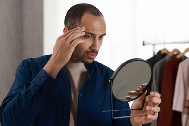 Photo of Handsome man looking at mirror at home