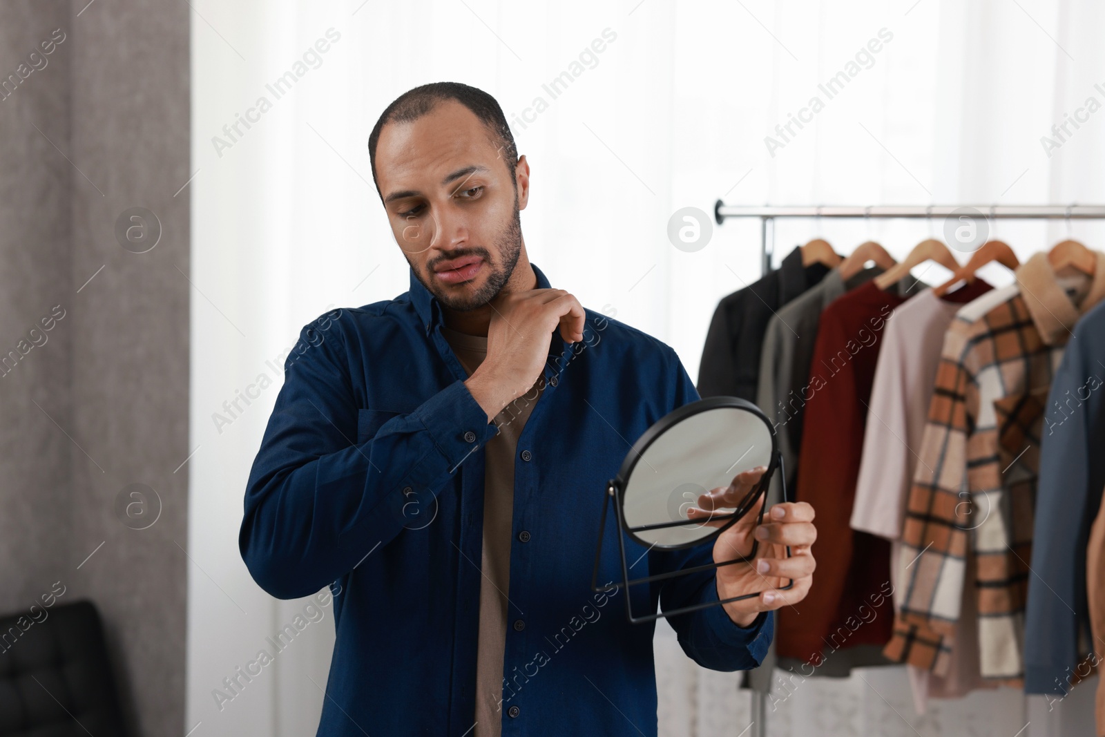 Photo of Handsome man looking at mirror at home