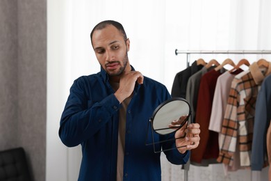 Photo of Handsome man looking at mirror at home