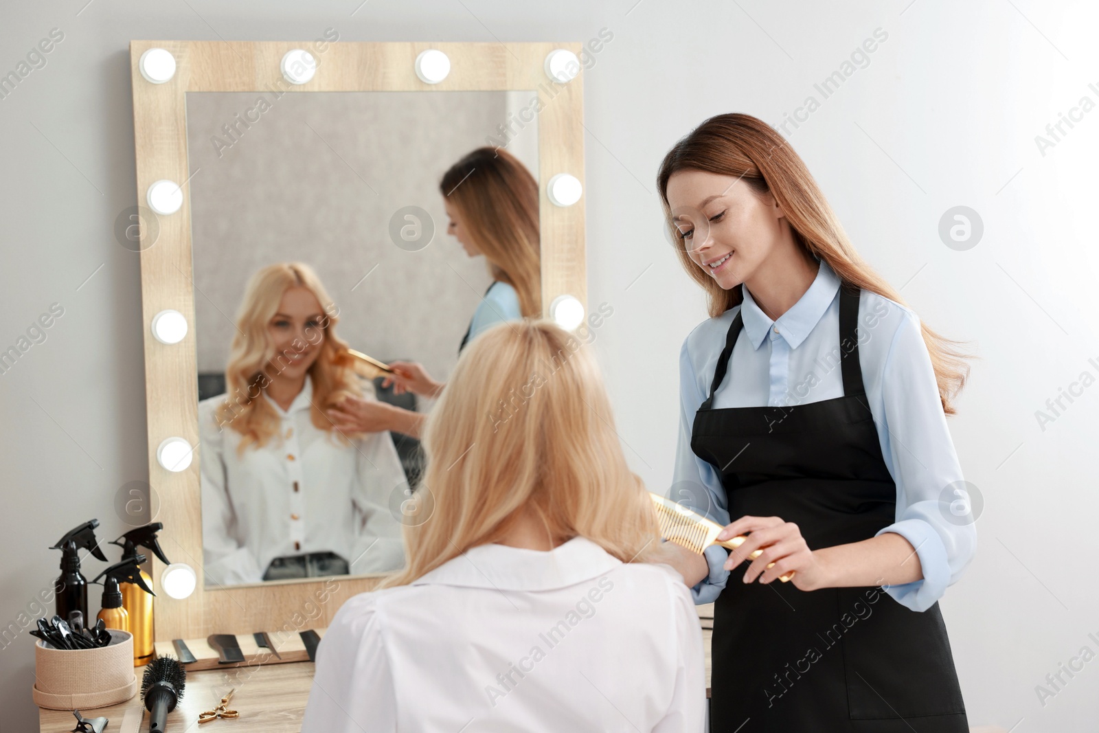 Photo of Hair cutting. Professional hairdresser working with client in salon