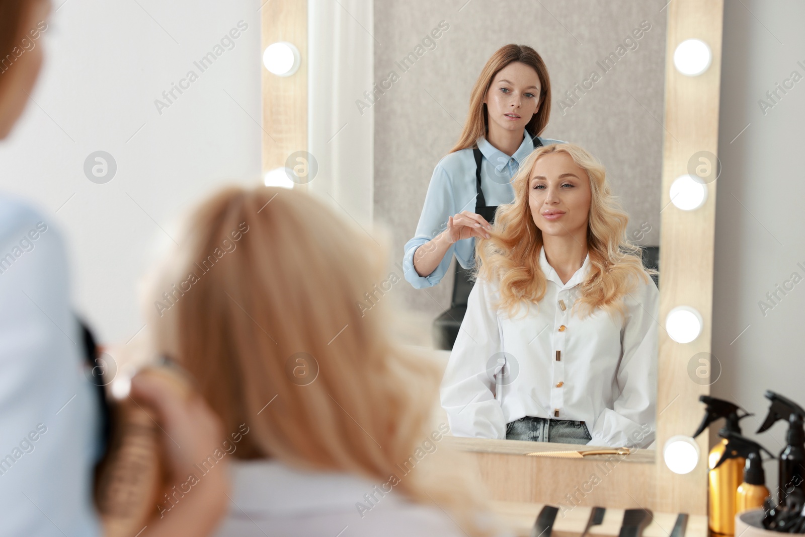 Photo of Hair cutting. Professional hairdresser working with client in salon, selective focus