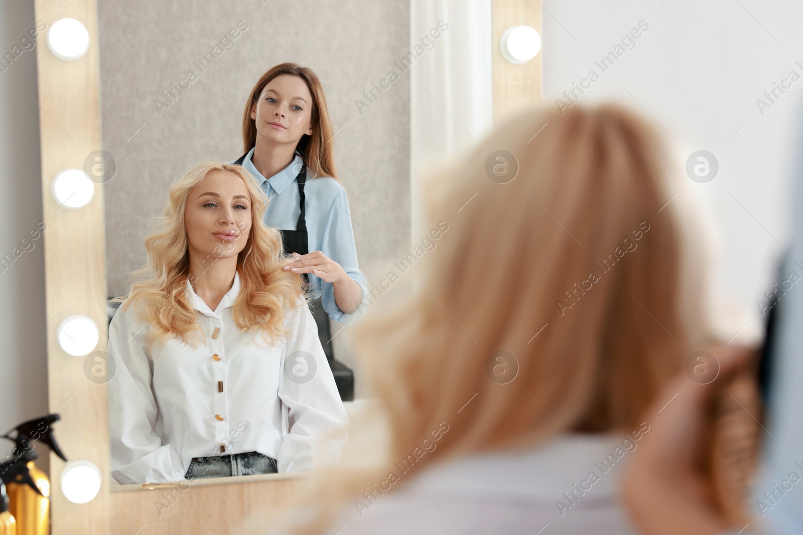 Photo of Hair cutting. Professional hairdresser working with client in salon, selective focus