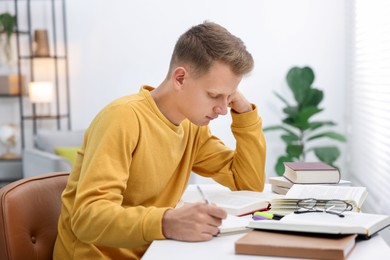 Photo of Student preparing for exam at table indoors