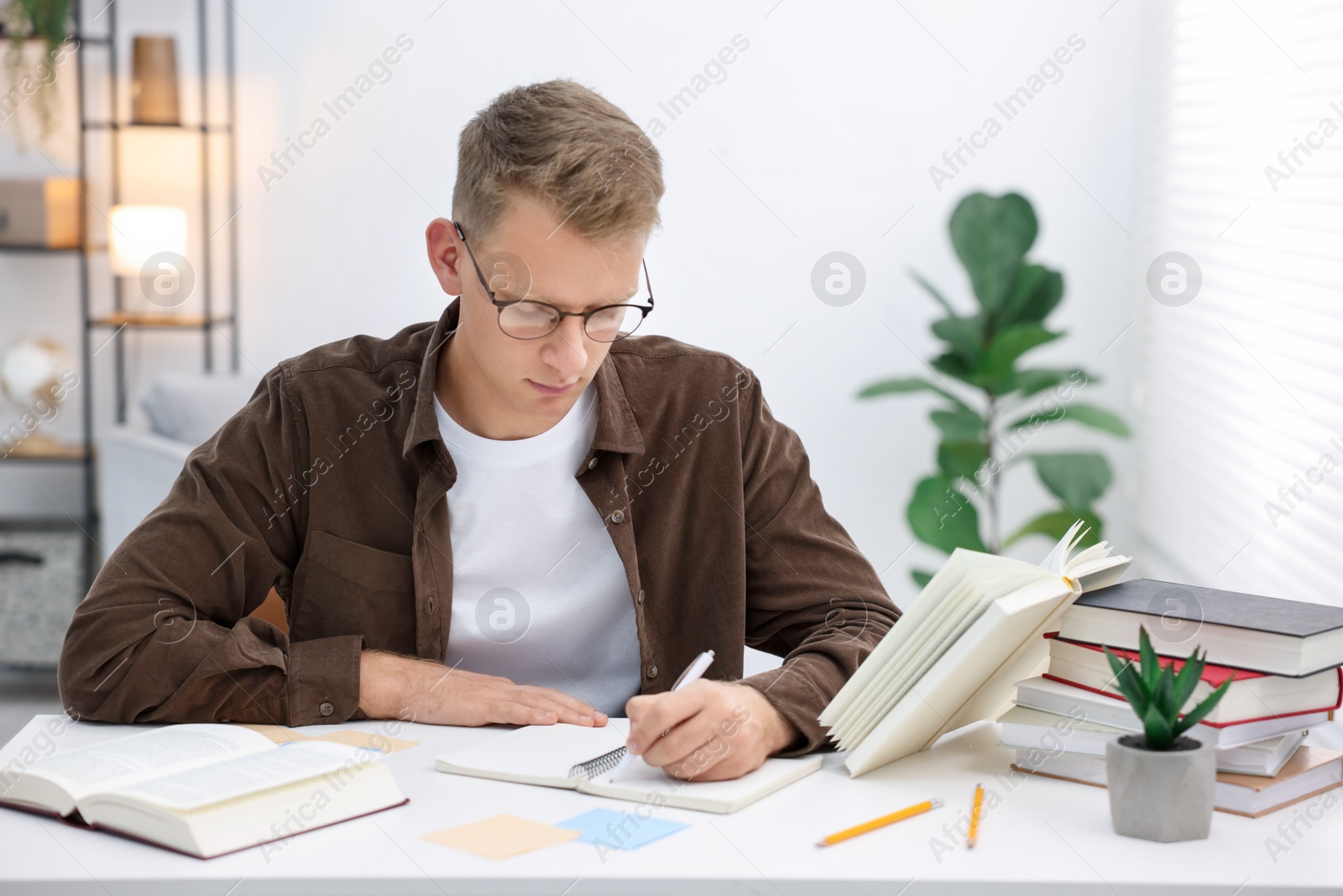 Photo of Student preparing for exam at table indoors