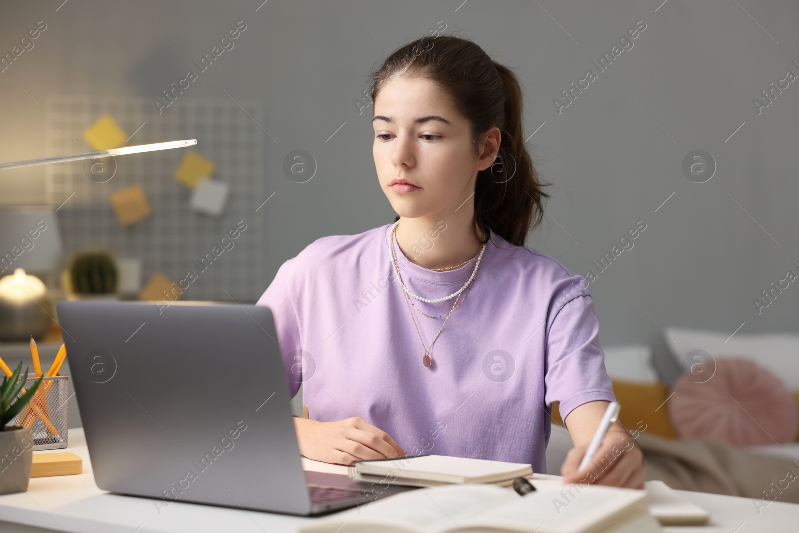 Photo of Student preparing for exam with laptop at table indoors