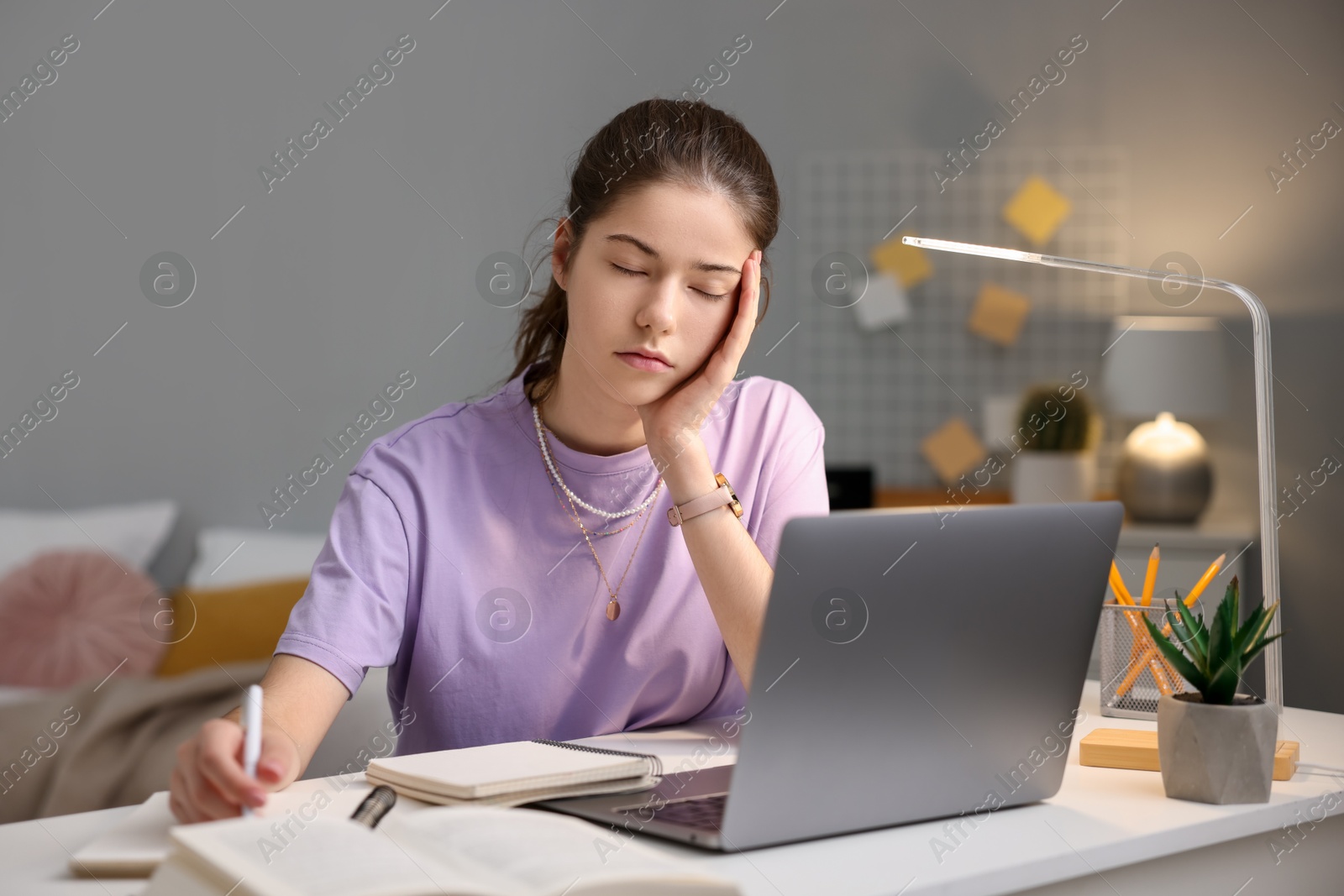 Photo of Preparing for exam. Tired student sleeping at table indoors