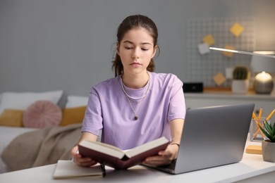 Photo of Student preparing for exam at table indoors