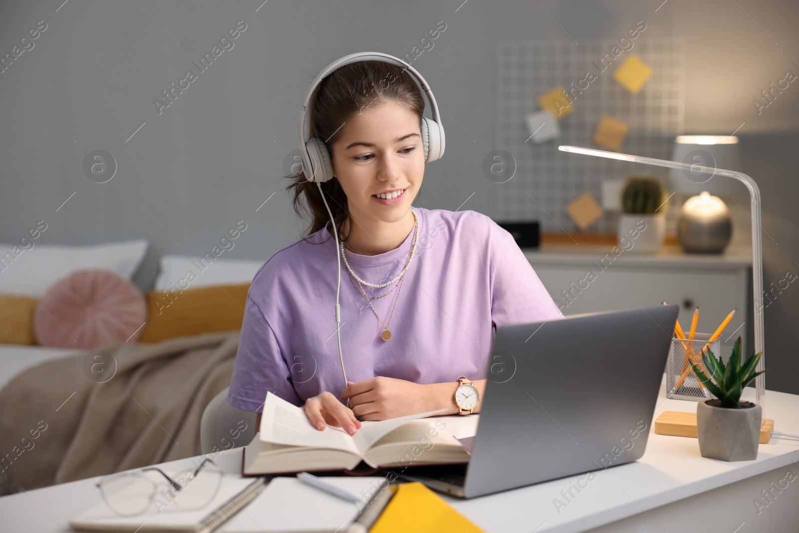 Photo of Student preparing for exam with laptop at table indoors