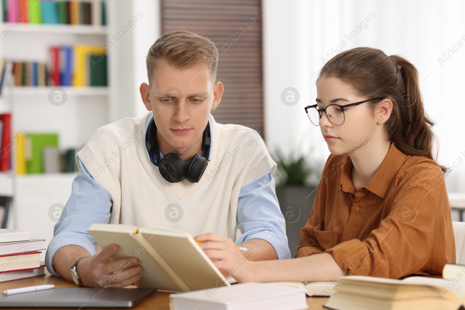 Photo of Students preparing for exam at table indoors