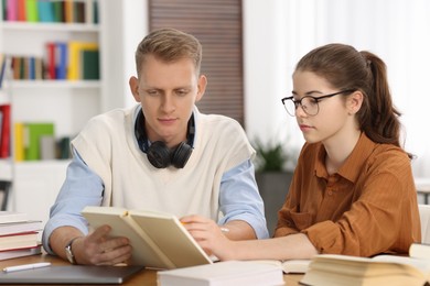 Photo of Students preparing for exam at table indoors