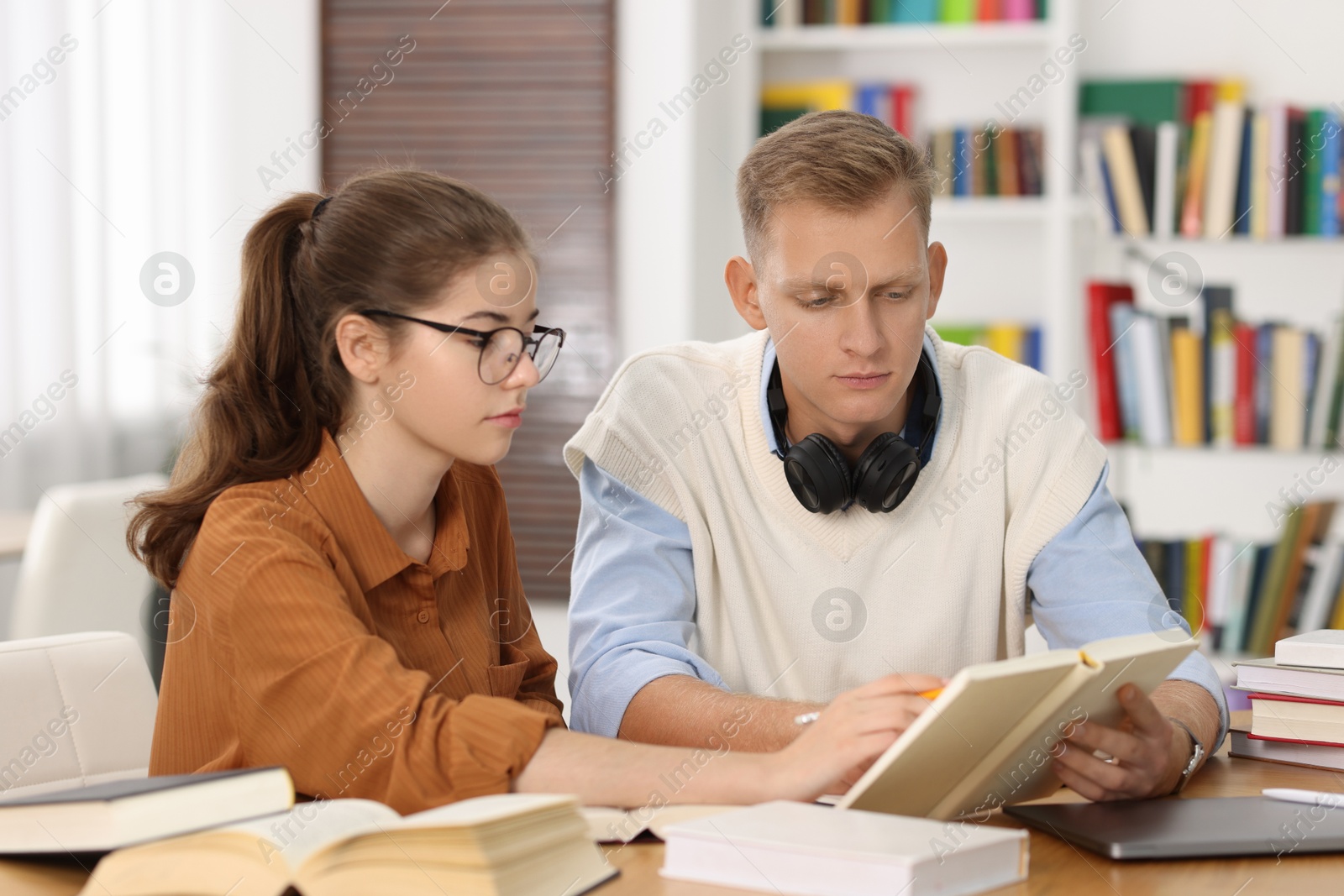 Photo of Students preparing for exam at table indoors