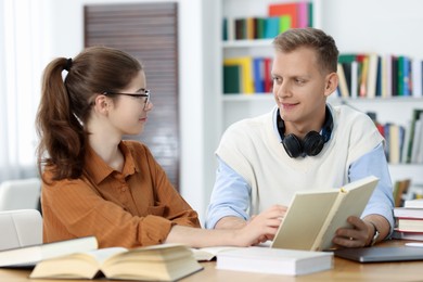 Photo of Students preparing for exam at table indoors