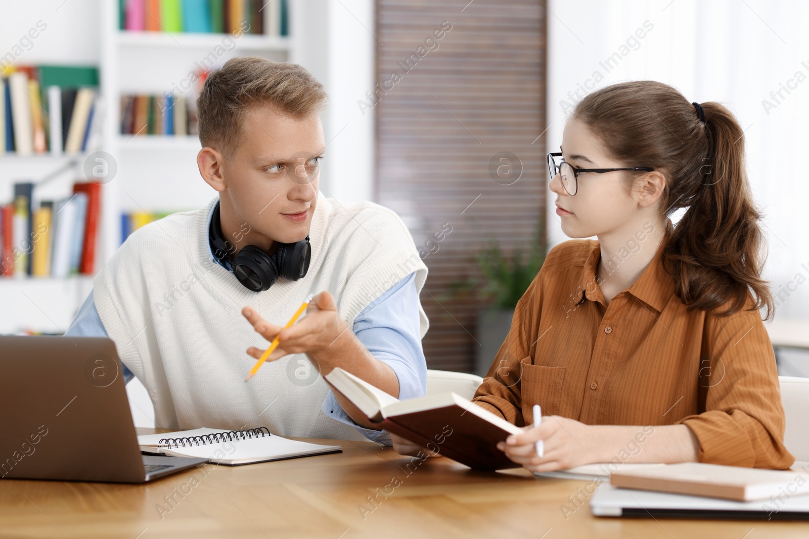 Photo of Students preparing for exam at table indoors