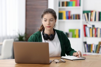 Student preparing for exam with laptop at table indoors