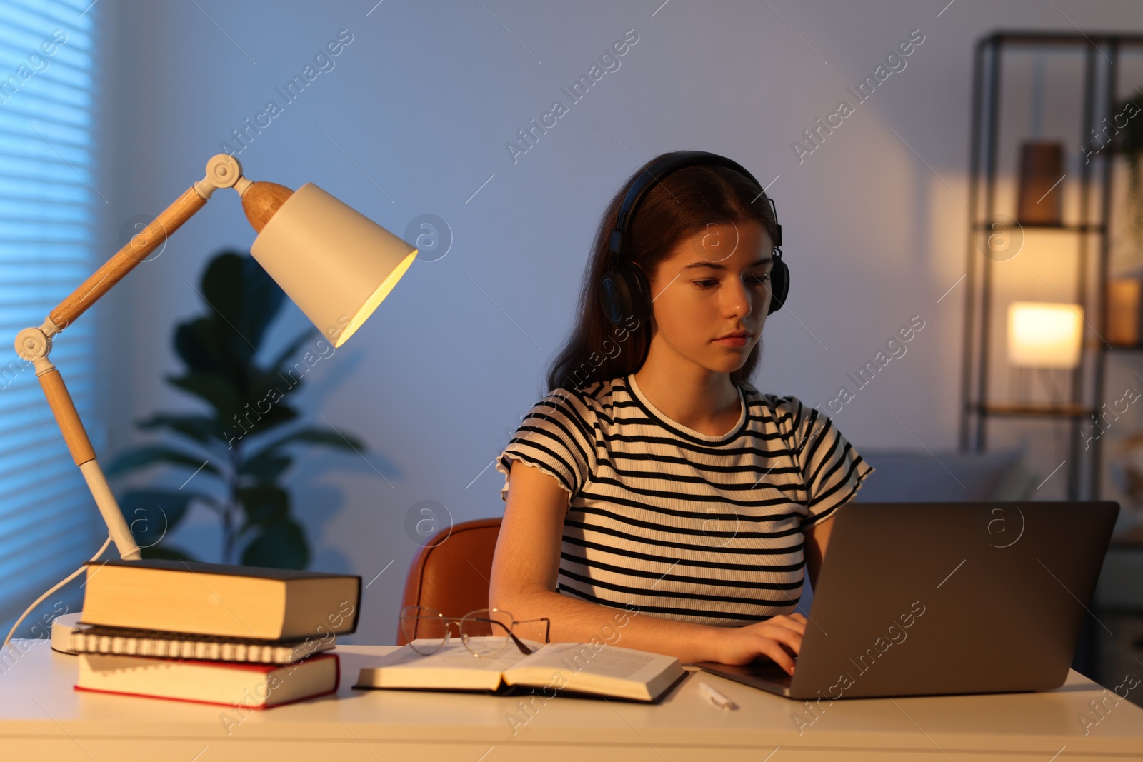 Photo of Student preparing for exam with laptop at table indoors