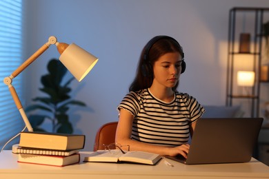 Photo of Student preparing for exam with laptop at table indoors