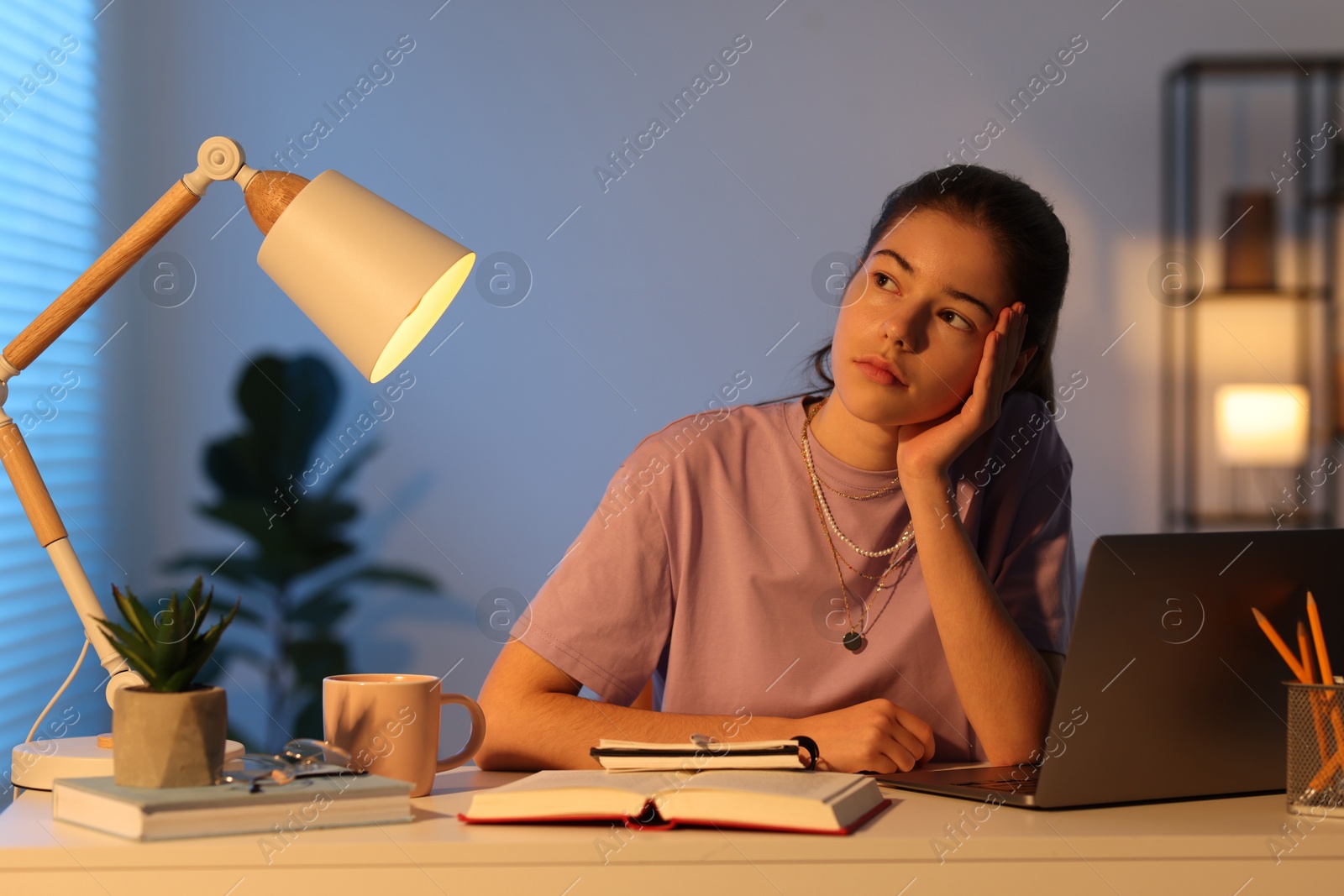 Photo of Preparing for exam. Student with laptop and books at table indoors