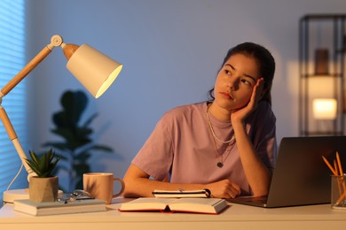 Preparing for exam. Student with laptop and books at table indoors