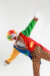 Portrait of emotional clown on light background