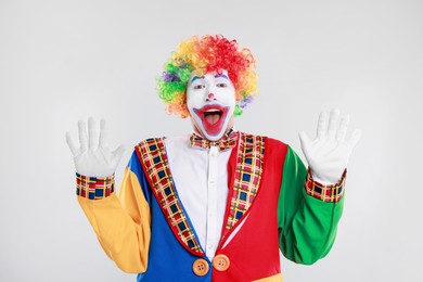 Photo of Portrait of emotional clown on light background