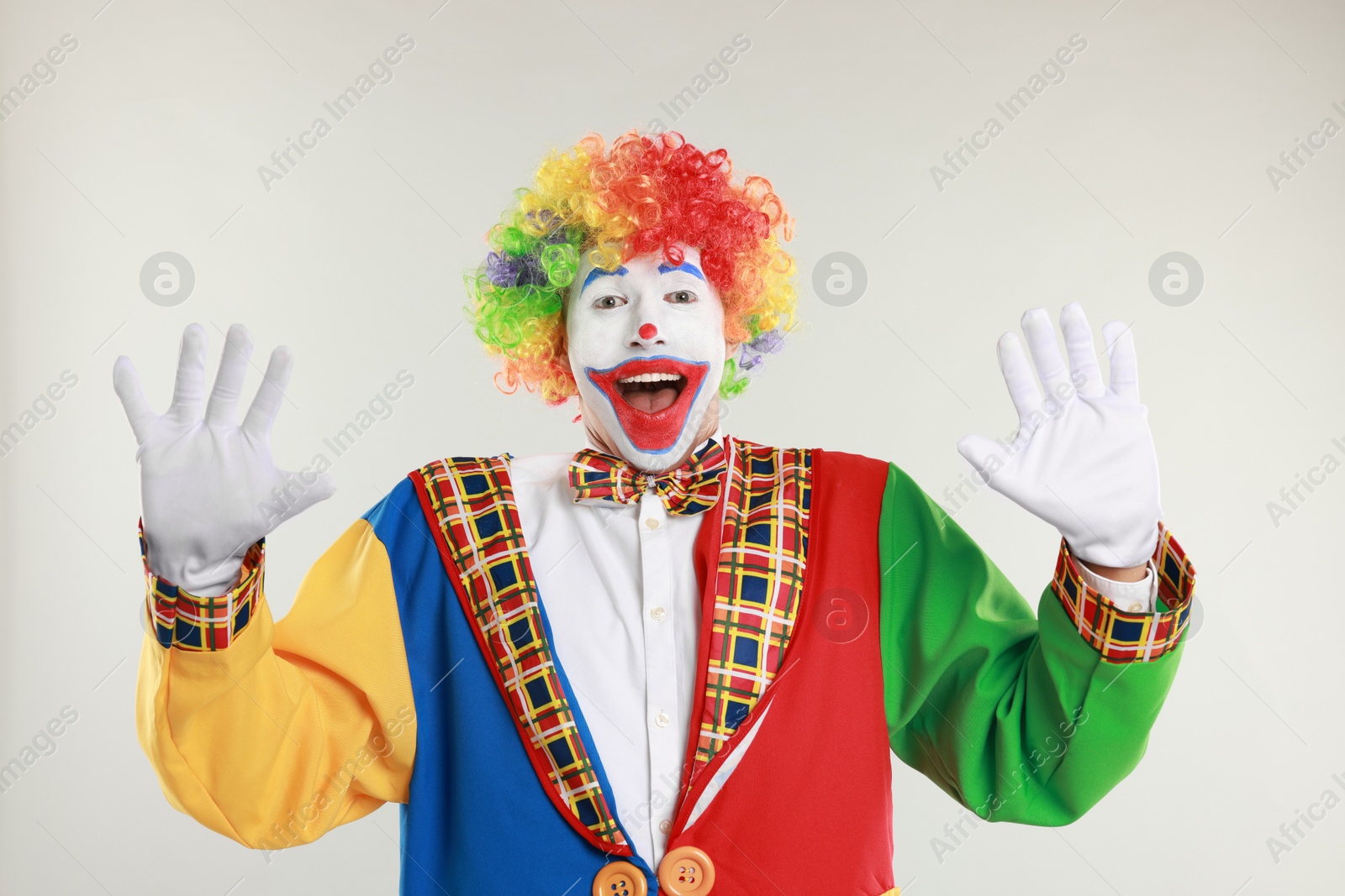 Photo of Portrait of happy clown on light background