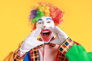 Photo of Portrait of clown screaming on yellow background