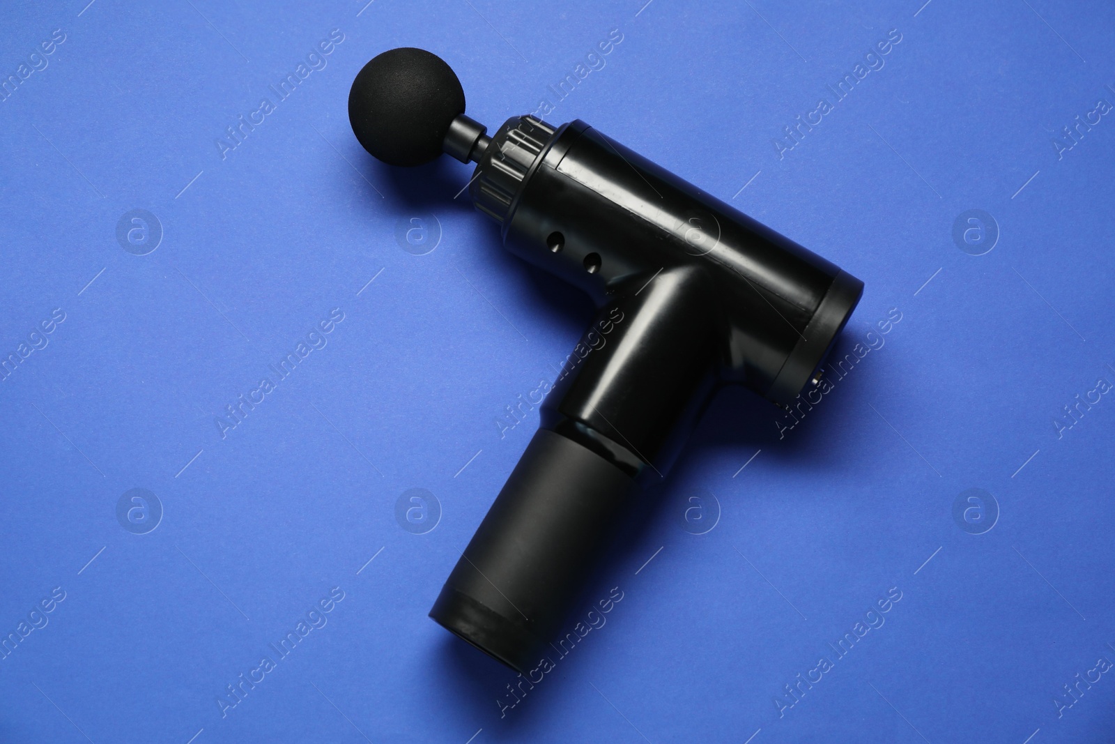 Photo of One black percussive massager on blue background, above view