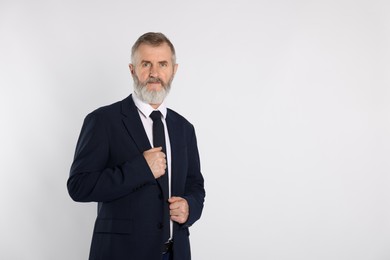 Photo of Portrait of senior man in suit on white background, space for text