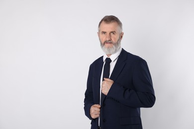 Photo of Portrait of senior man in suit on white background, space for text