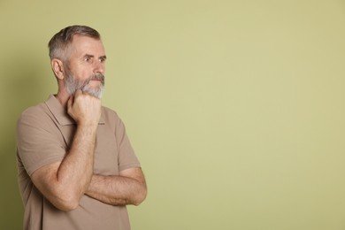 Photo of Portrait of senior man on green background, space for text