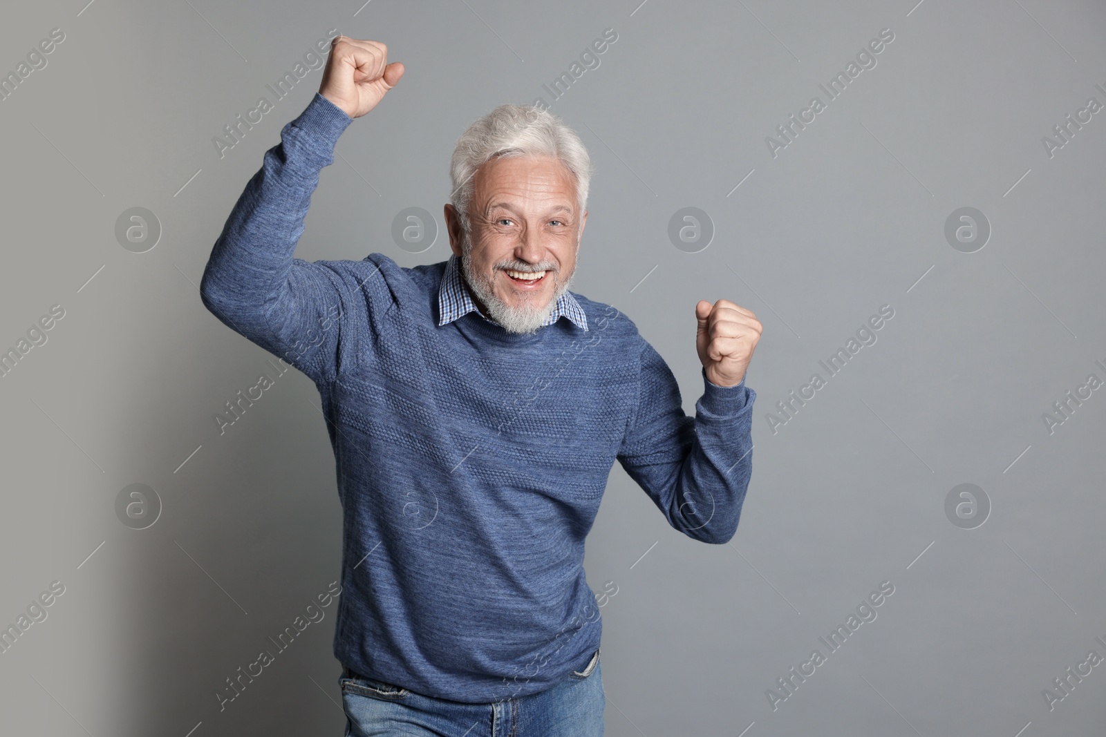 Photo of Portrait of happy senior man on grey background