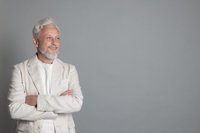 Portrait of senior man on grey background, space for text