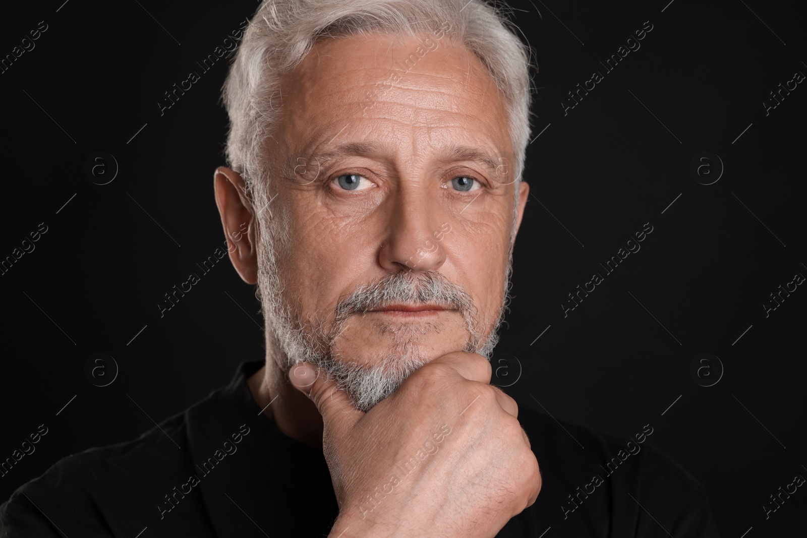 Photo of Portrait of senior man on black background