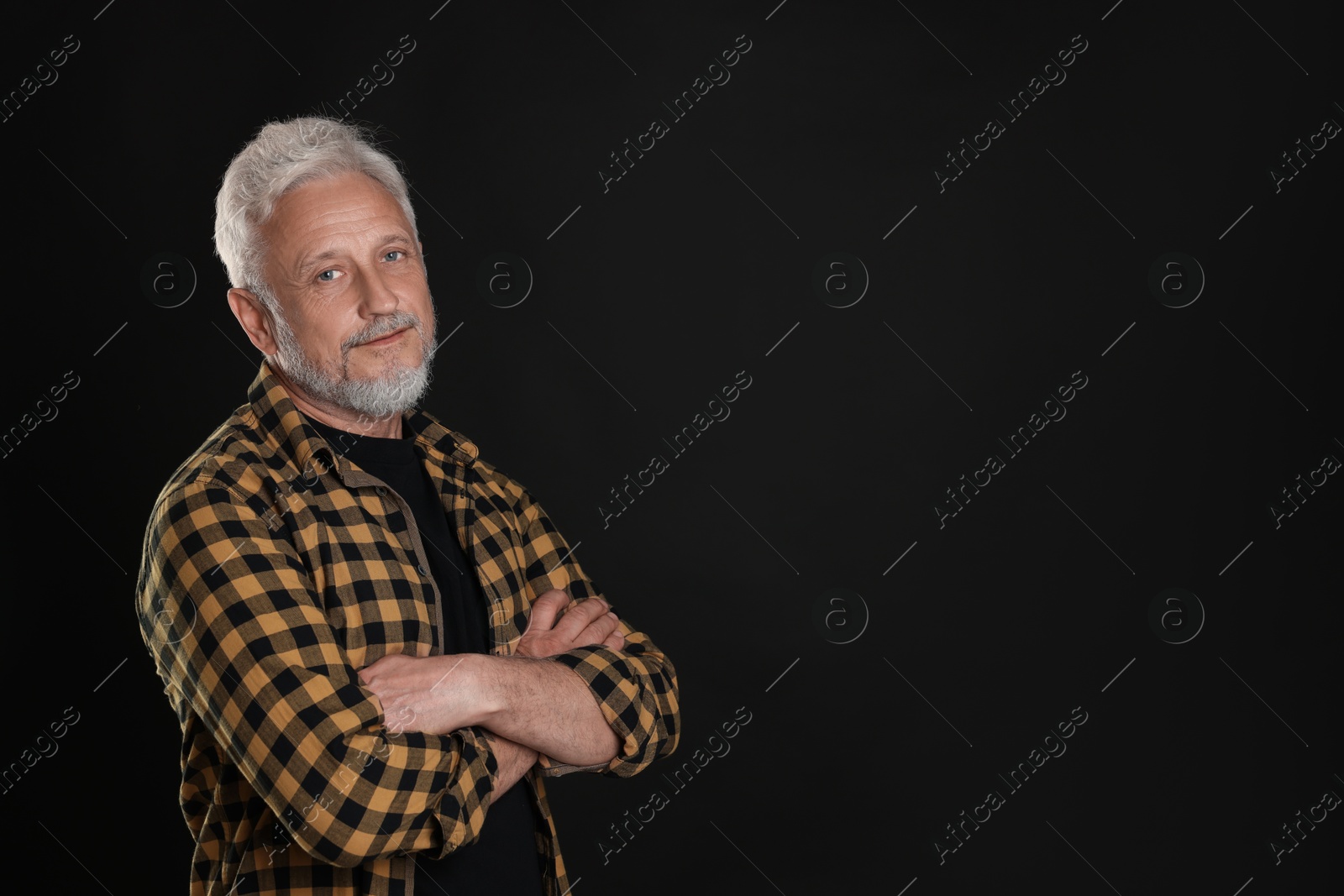 Photo of Portrait of senior man on black background, space for text