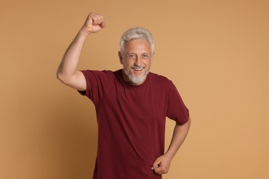 Photo of Portrait of happy senior man on beige background