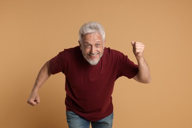 Photo of Portrait of happy senior man on beige background