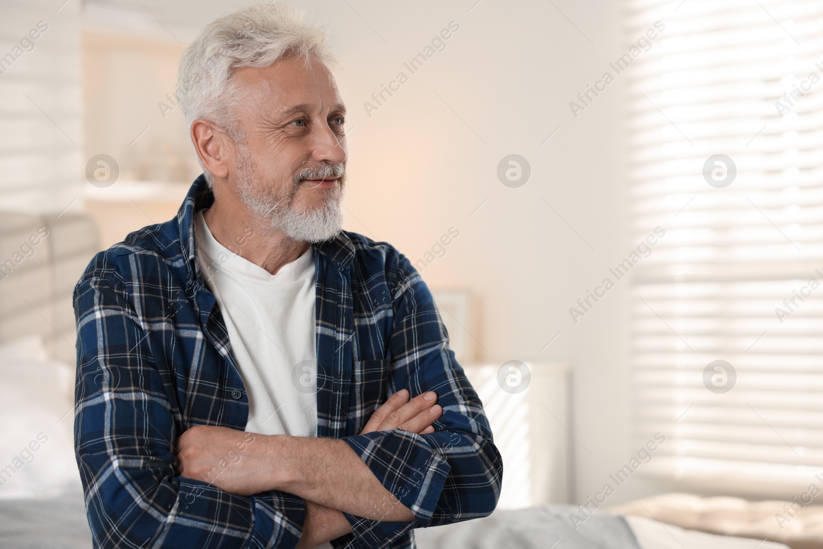 Photo of Portrait of senior man with grey hair at home, space for text