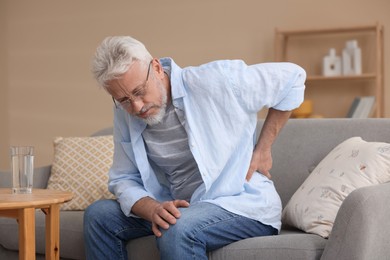 Senior man suffering from backache at home