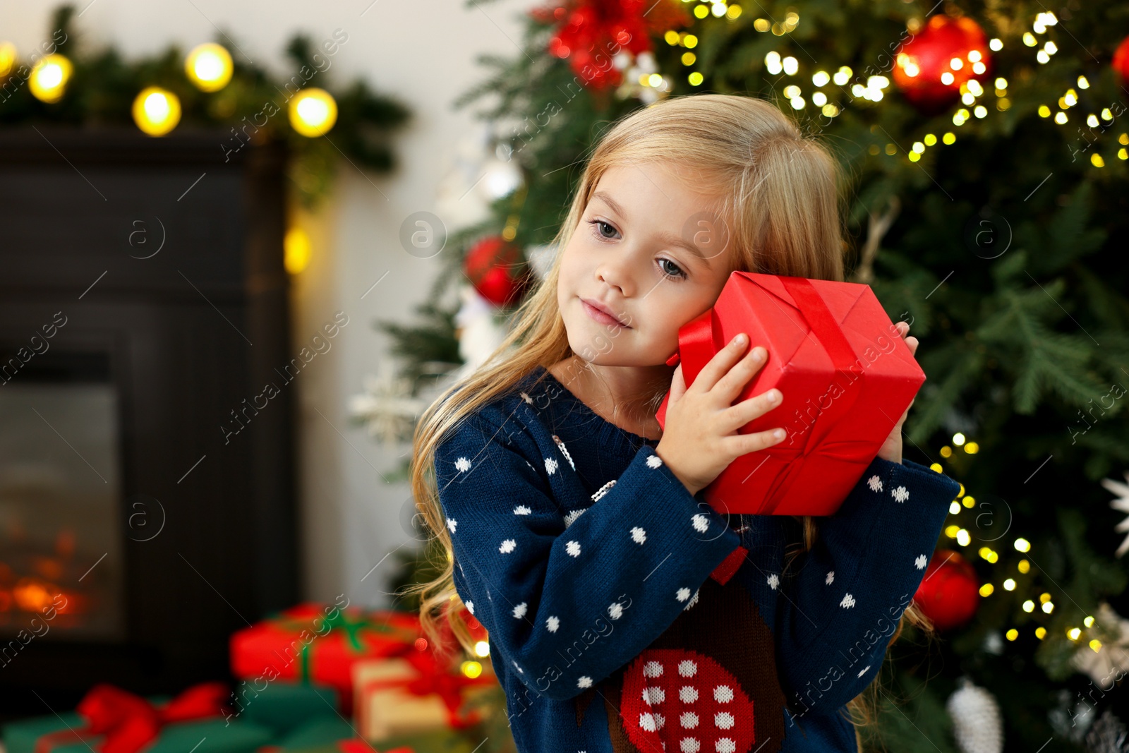 Photo of Little girl with Christmas gift at home, space for text