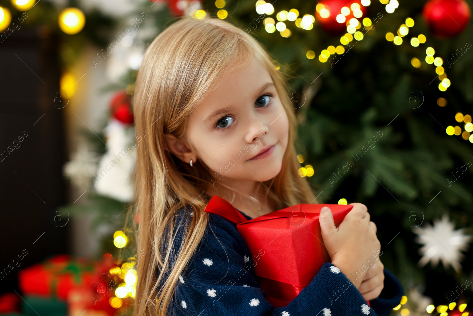 Photo of Little girl with Christmas gift at home