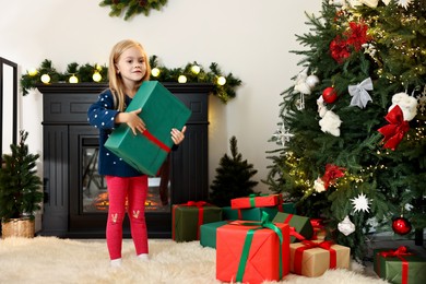 Little girl with Christmas gift at home