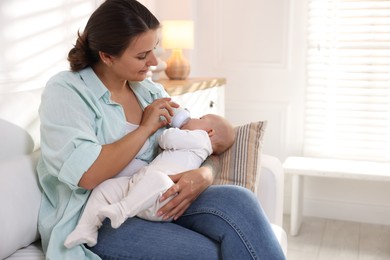 Mother feeding her cute baby at home